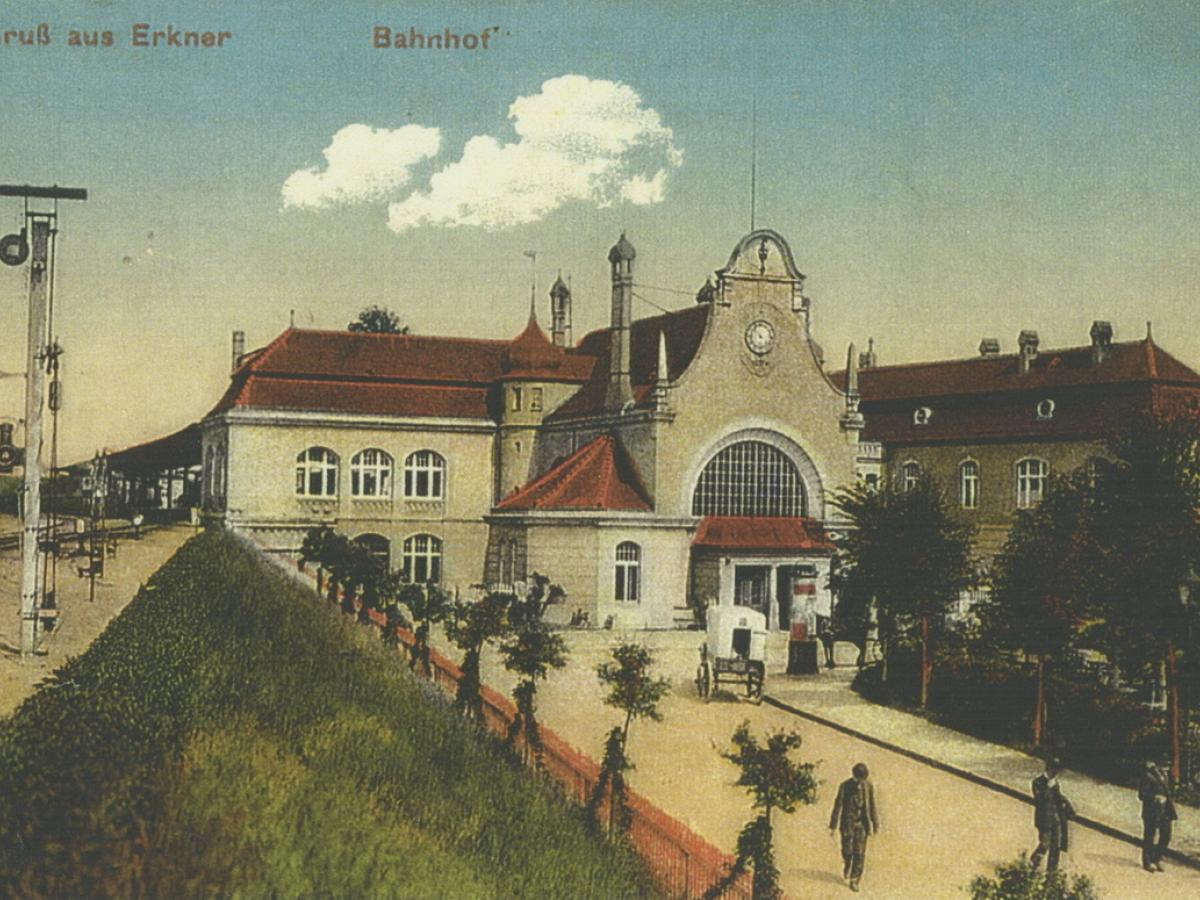 um 1910: handcolorierte Postkarte mit Bahnhofsvorplatz